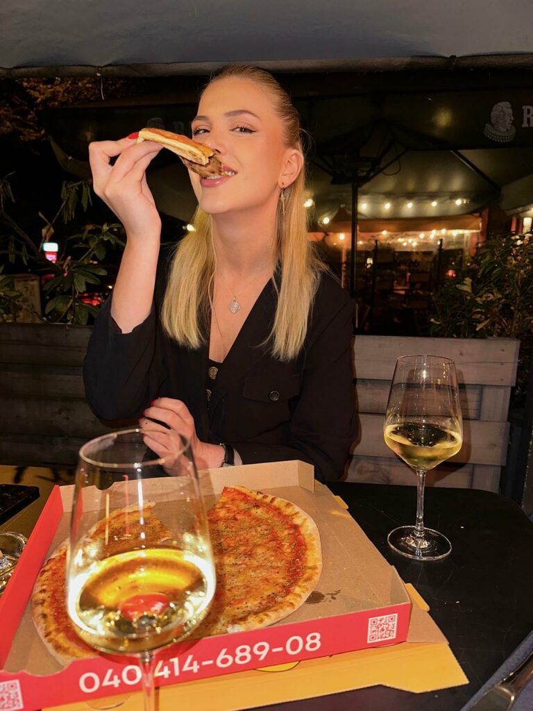 Sylvie Kahl isst ein Stück Pizza in der Clermont Weinbar in Pöseldorf